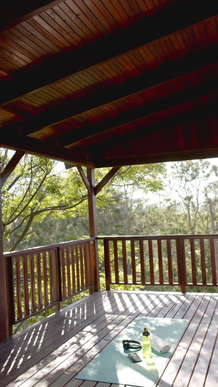 Slow-motion vertical video shows water bottle, towel, headphones, and phone on cabin mat