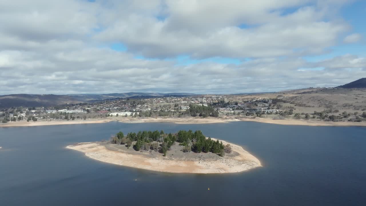 Drone flying over Lion Island on Lake Jindabyne towards the town, Australia