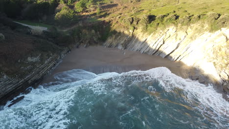 muriola-beach:-aerial-view-in-orbit-at-the-shore-of-the-beautiful-beach-on-a-sunny-day-in-Barrika,-Vizcaya