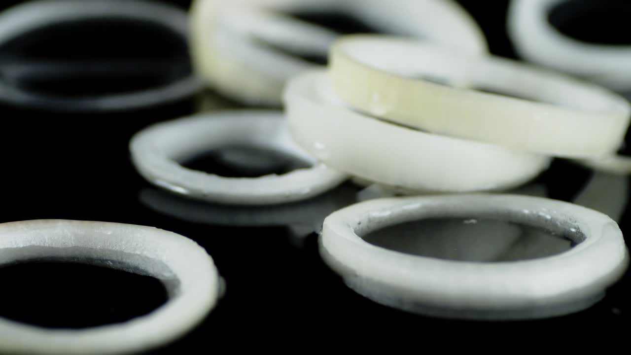 신선한 양파의 반지는 물에 어지며 떨어집니다.