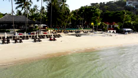 Toma-De-Drone-A-La-Altura-De-Los-Ojos-Moviéndose-De-Izquierda-A-Derecha-Del-Encuadre,-Mostrando-La-Playa-De-Arena,-Aguas-Cristalinas-Y-Una-Vista-Panorámica-De-Los-Alojamientos-En-La-Bahía-De-Thongson,-Samui,-Tailandia.