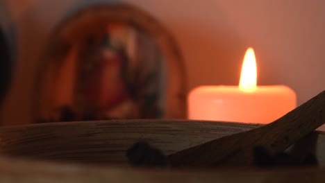 relaxing background detail shot of an herbal tea shop, with candles with flickering flames, herbs, a wooden bowl and some dust flying around