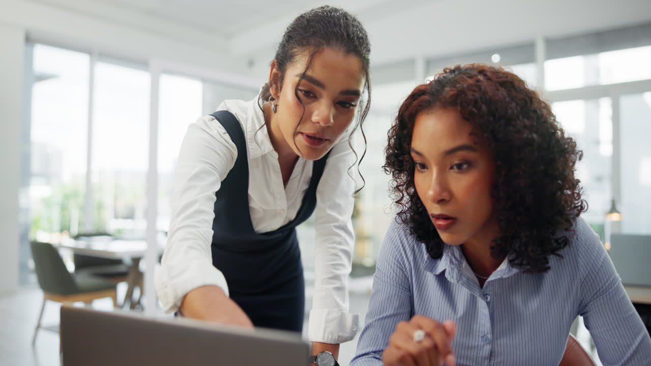 Two businesswomen working together on a laptop