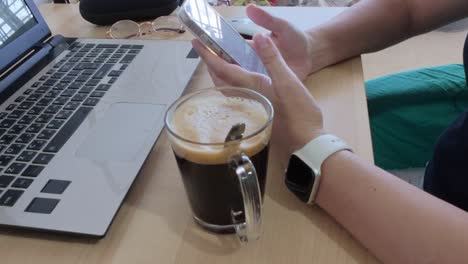 freelancer's workspace: hands on phone, laptop, coffee. essential tools for independent work