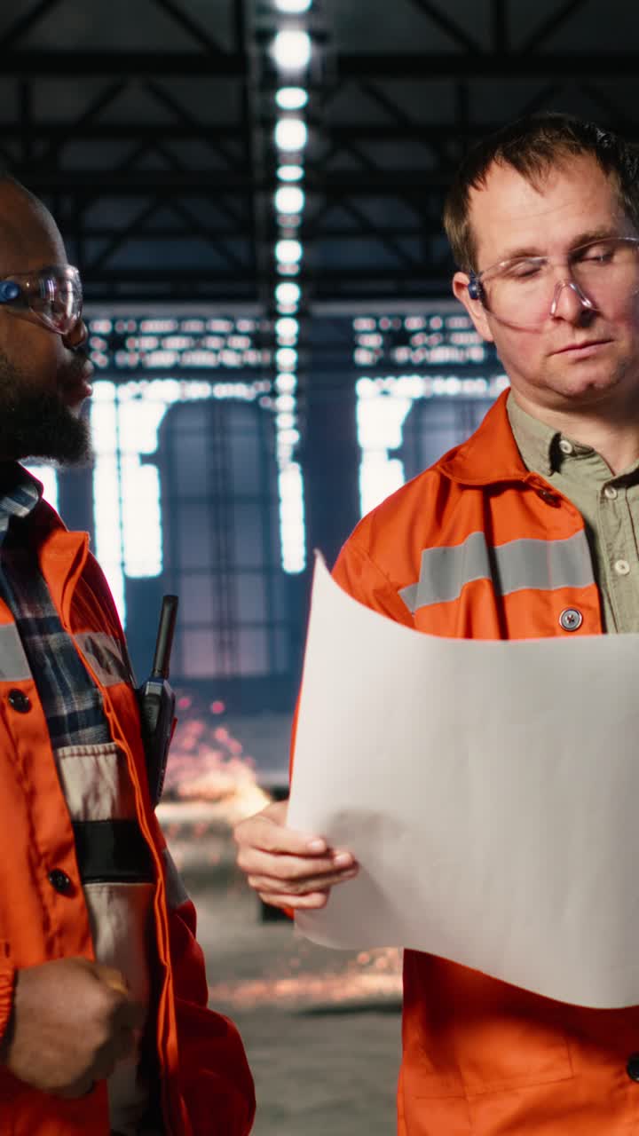 Vertical Video Diverse engineers handling assembly workflow with industrial plans