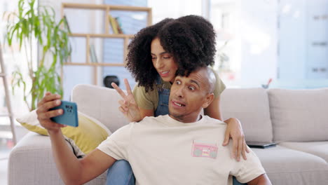 Couple,-selfie-and-peace-sign-with-kiss-in-home