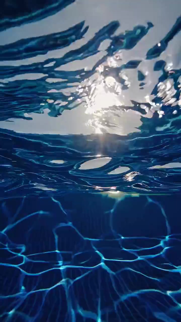 Piscina blu brillante con galleggianti gonfiabili e riflessi di luce subacquei