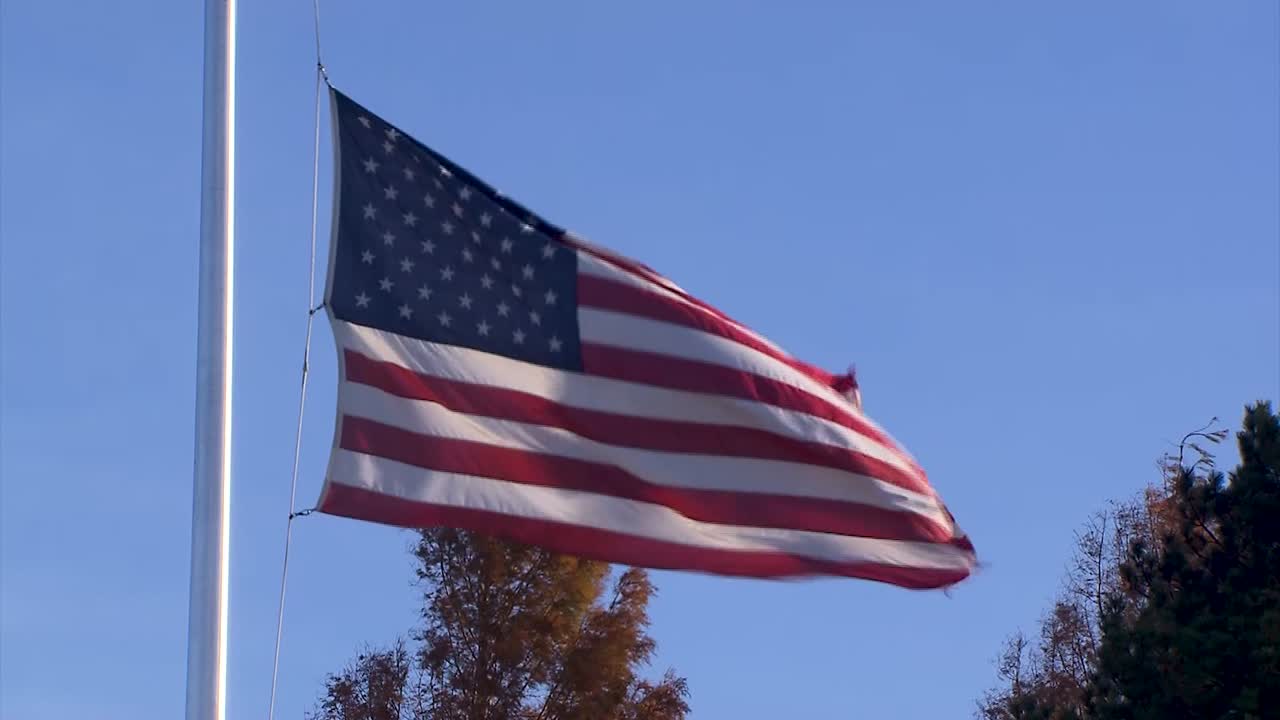 AMERICAN FLAG AT HALF STAFF ON A WINDY DAY