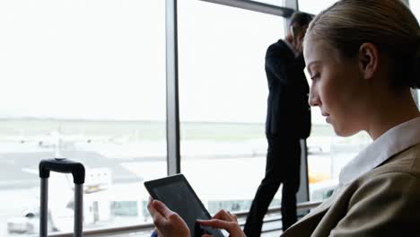 Mujer-De-Negocios-Usando-Tableta-Digital-Y-Sonriendo-En-El-Aeropuerto