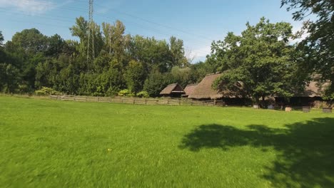 historic, renovated rural cottages surrounded by greenery in an urban open-air museum in poland during the summer