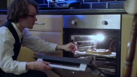 un joven tiene su pizza en el horno y se prepara para una comida