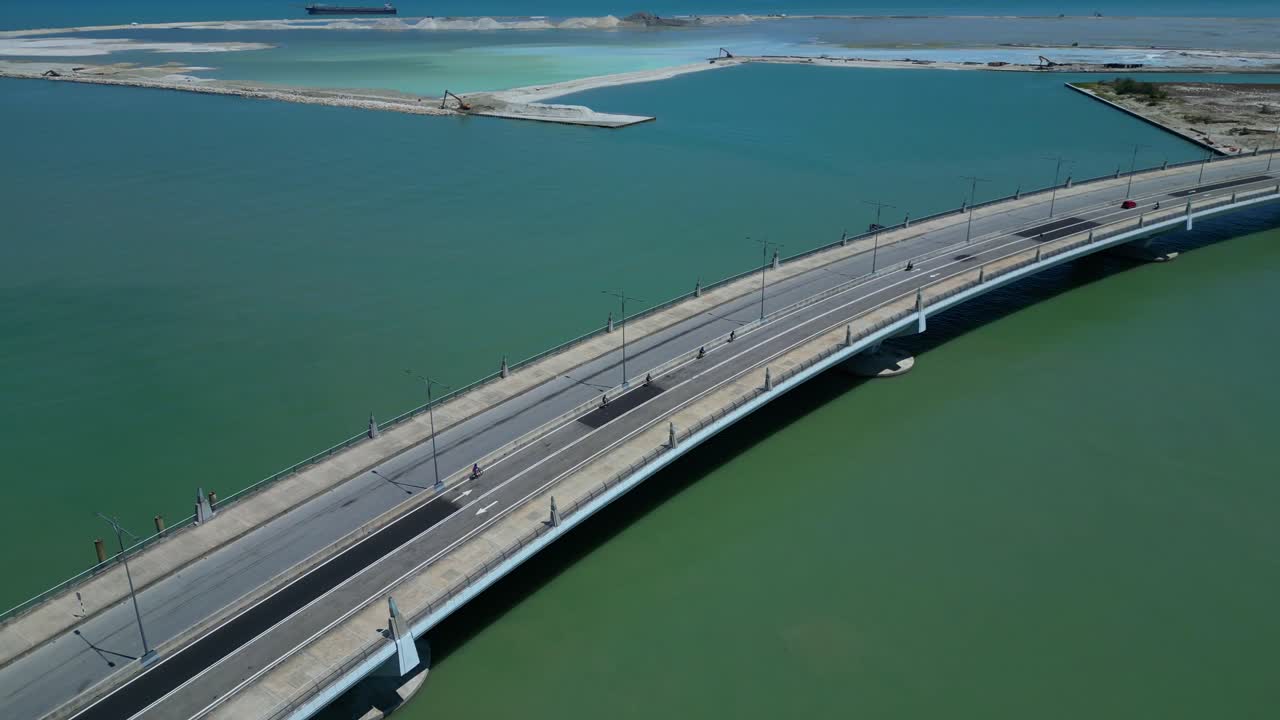 Gurney Drive kyst, viser trafik på bro, kunstig ø og igangværende landindvinding. Spektakulær luftfoto droneoverflyvning.