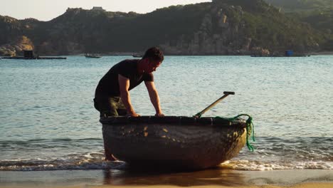 Fischer-Nimmt-Coracle-boot-Zum-Angeln,-Strand-Von-Vinh-Hy-Bay,-Vietnam