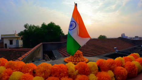 indian flag with marigold garland on rooftop at sunrise