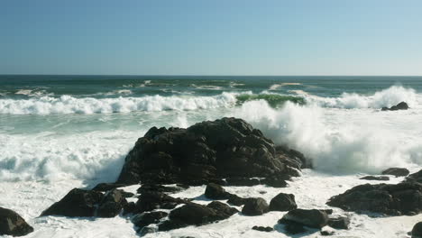 powerful foamy waves splashing on coastal rocks at west coast national park, south africa - drone shot