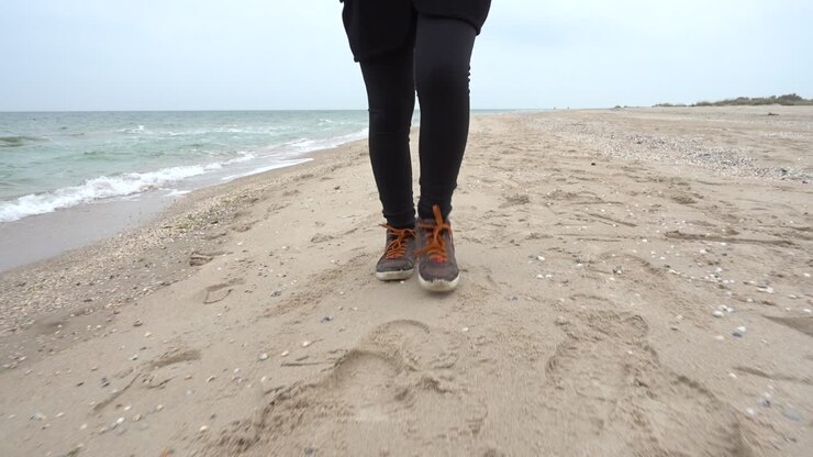 Das Mädchen geht am Strand entlang. Aufnahmen am Strand