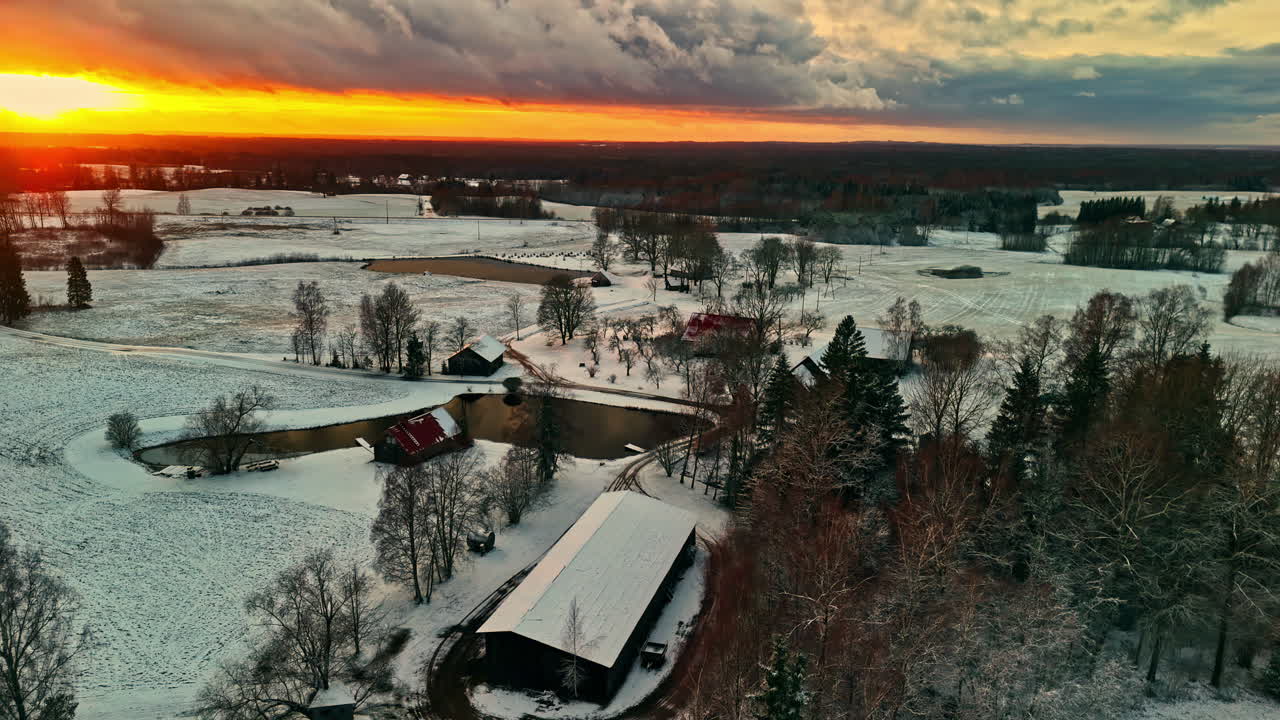 A snowy countryside at sunset, serene winter mood with vibrant skies , aerial view