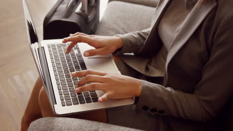 Smiling-businesswoman-using-her-laptop-on-the-couch