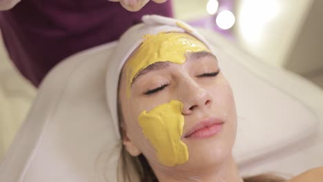 mujer recibiendo un tratamiento de máscara facial