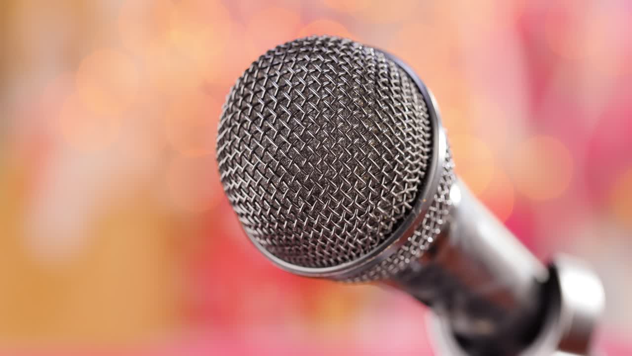 Microphone on stage against a blurry light ,blurry background.