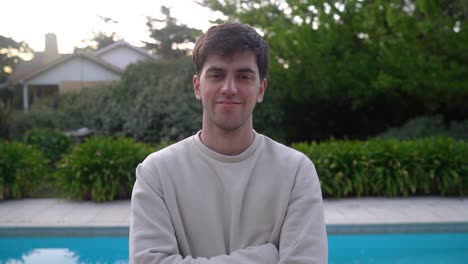 Portrait-Of-A-Smiling-Young-Man-Standing-Near-Swimming-Pool