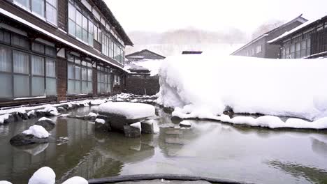 la nieve en cámara lenta cae fuera del onsen tradicional, japón