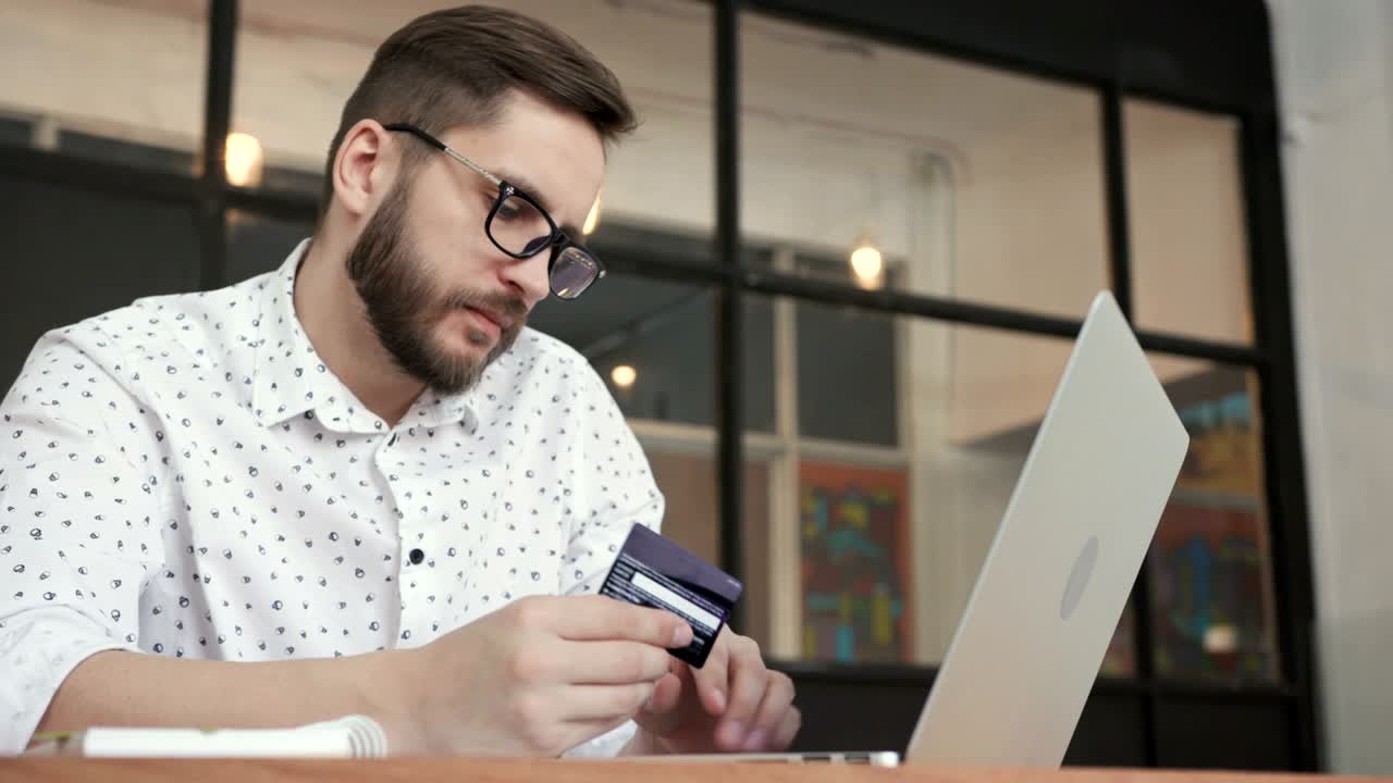 Uomo che utilizza il banking online con laptop e carta.