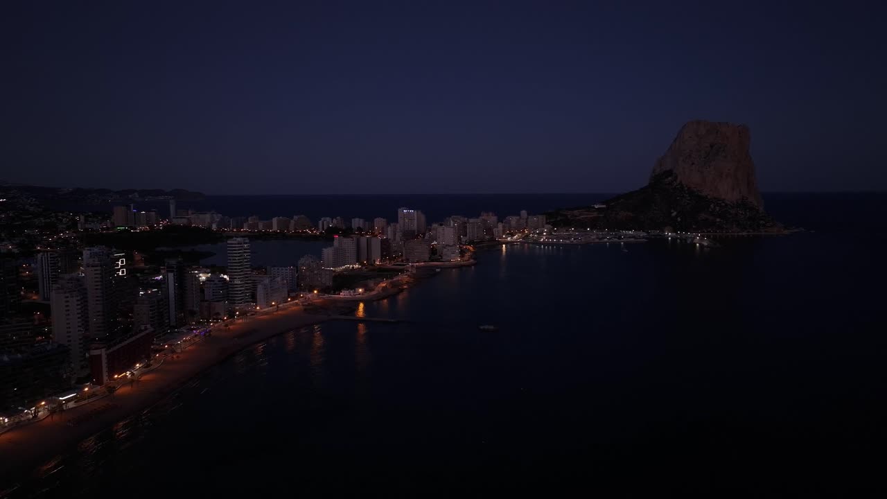 Splendida ripresa con drone del villaggio di Calpe, Spagna, di notte, con le luci degli edifici accese