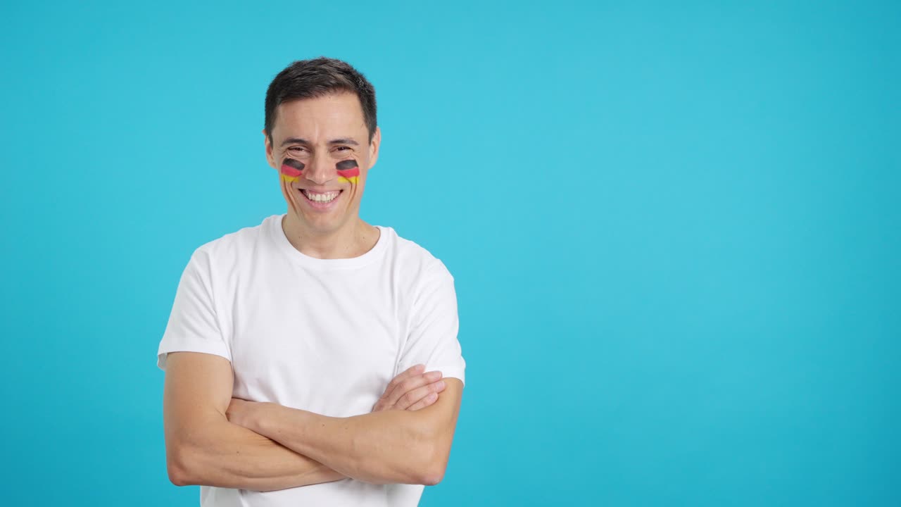 Man standing with german flag painted on face smiling