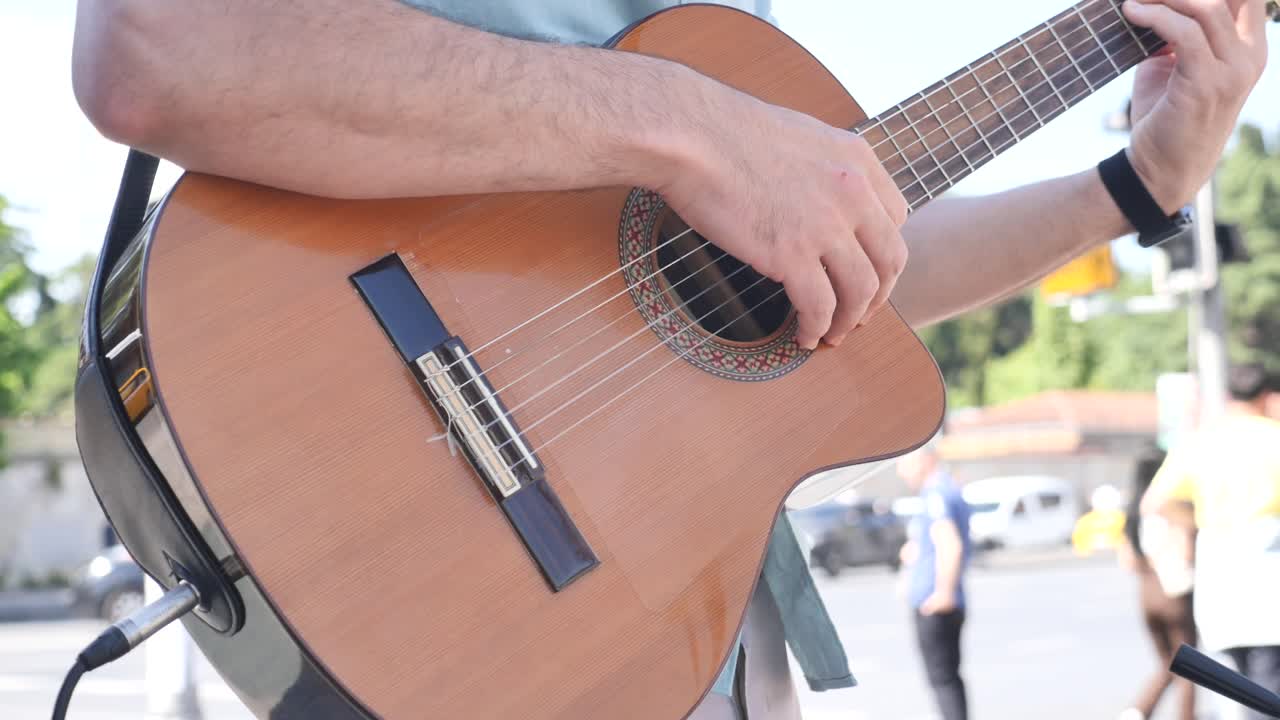 hombre tocando la guitarra acústica en la calle