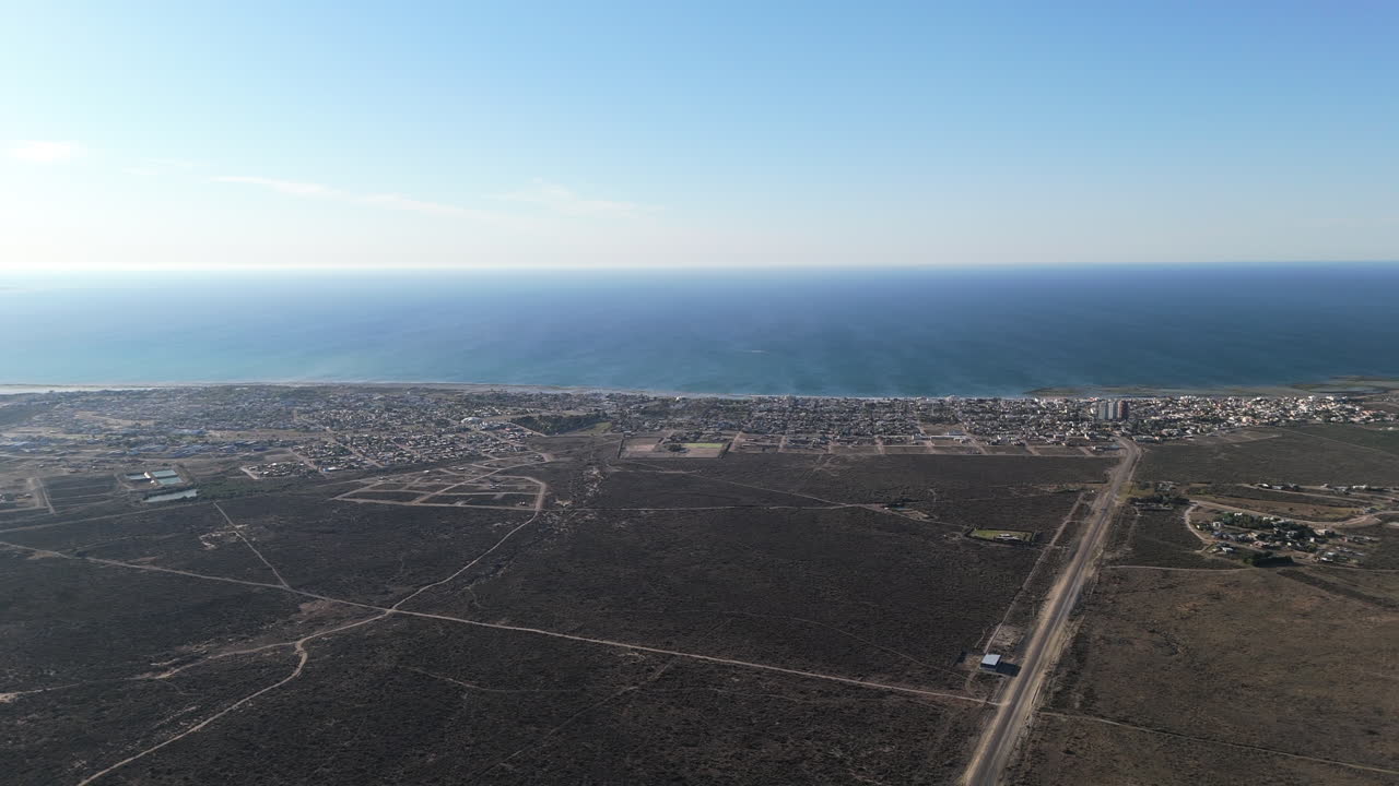 Great aerial shot of Las Grutas, Rio Negro, Patagonia Argentina. Panoramic view of the access road to the city with the sea in the background and a completely clear horizon.