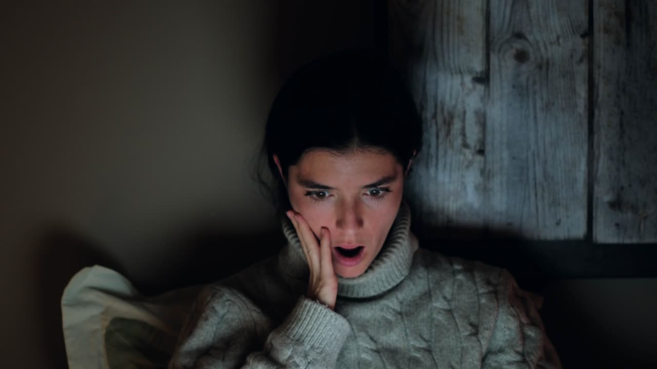 joven reaccionando al contenido chocante en la computadora portátil