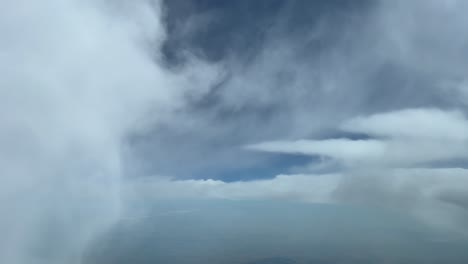impresionante punto de vista del piloto mientras volaba a nivel de crucero a través de nubes blancas esponjosas en un cielo azul profundo de verano