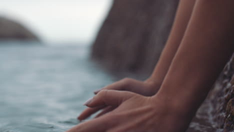 Woman-hands-in-the-water-from-the-ocean-waves