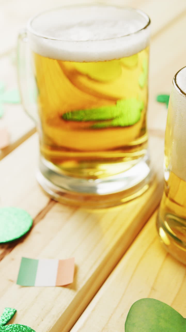 Animation of st patrick's green shamrock and beer with copy space on wooden background