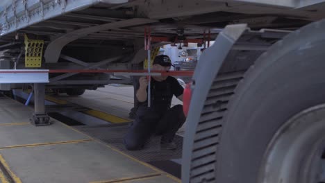 auto mechanic checks axle stabilizer truck