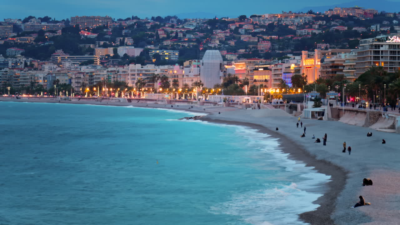 Vista distante della Promenade des Anglais lungo la costa mediterranea della città di Nizza, in Francia, di sera
