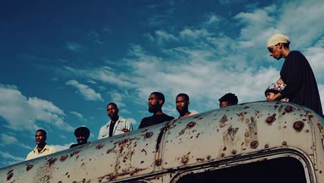 diverse group on top of an old bus