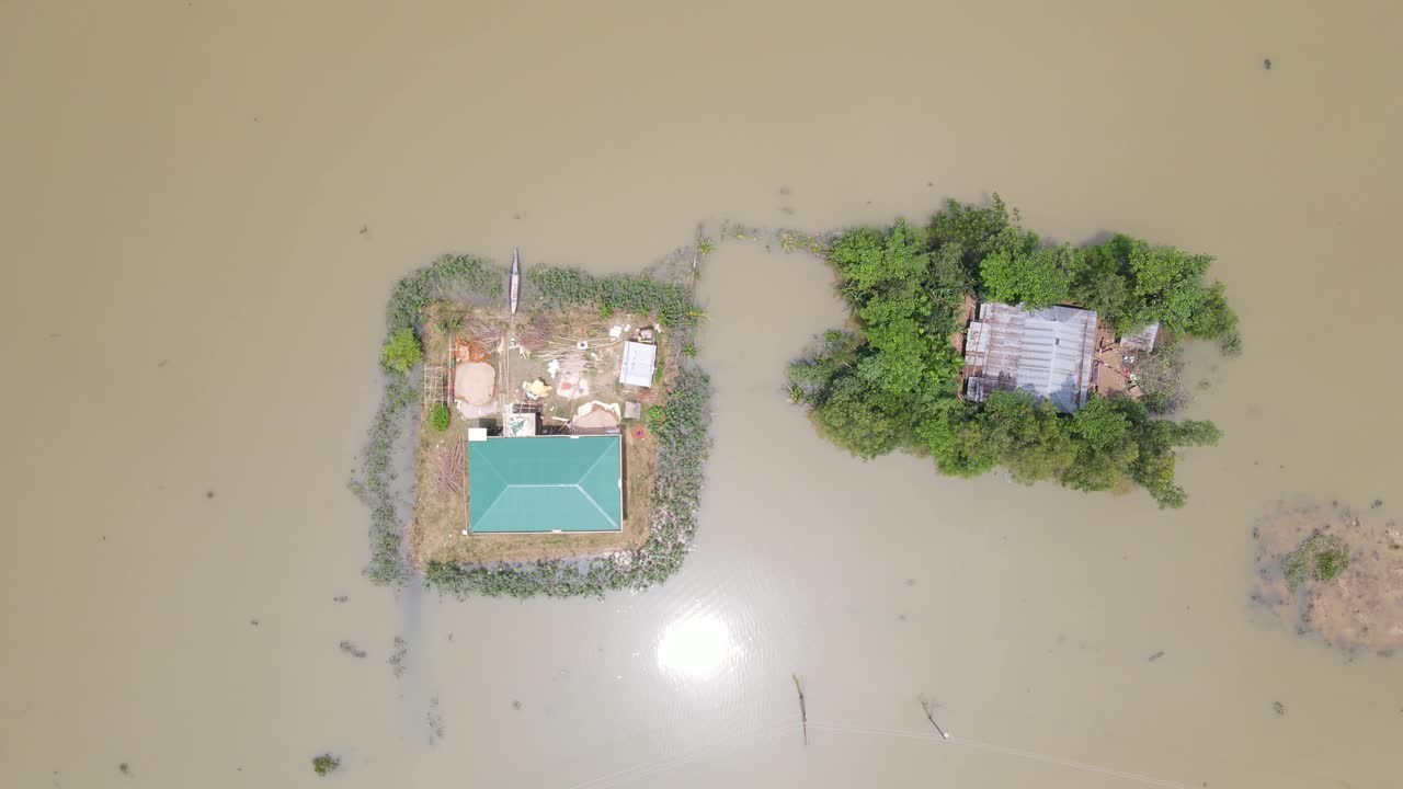 Remote houses surrounded by flood water in natural disaster, aerial view in Bangladesh village, South Asia