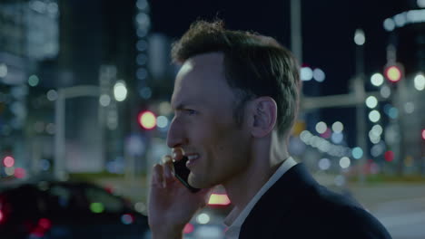 Elegant-young-man-making-gesticulating-while-talking-on-phone-in-the-street-at-night