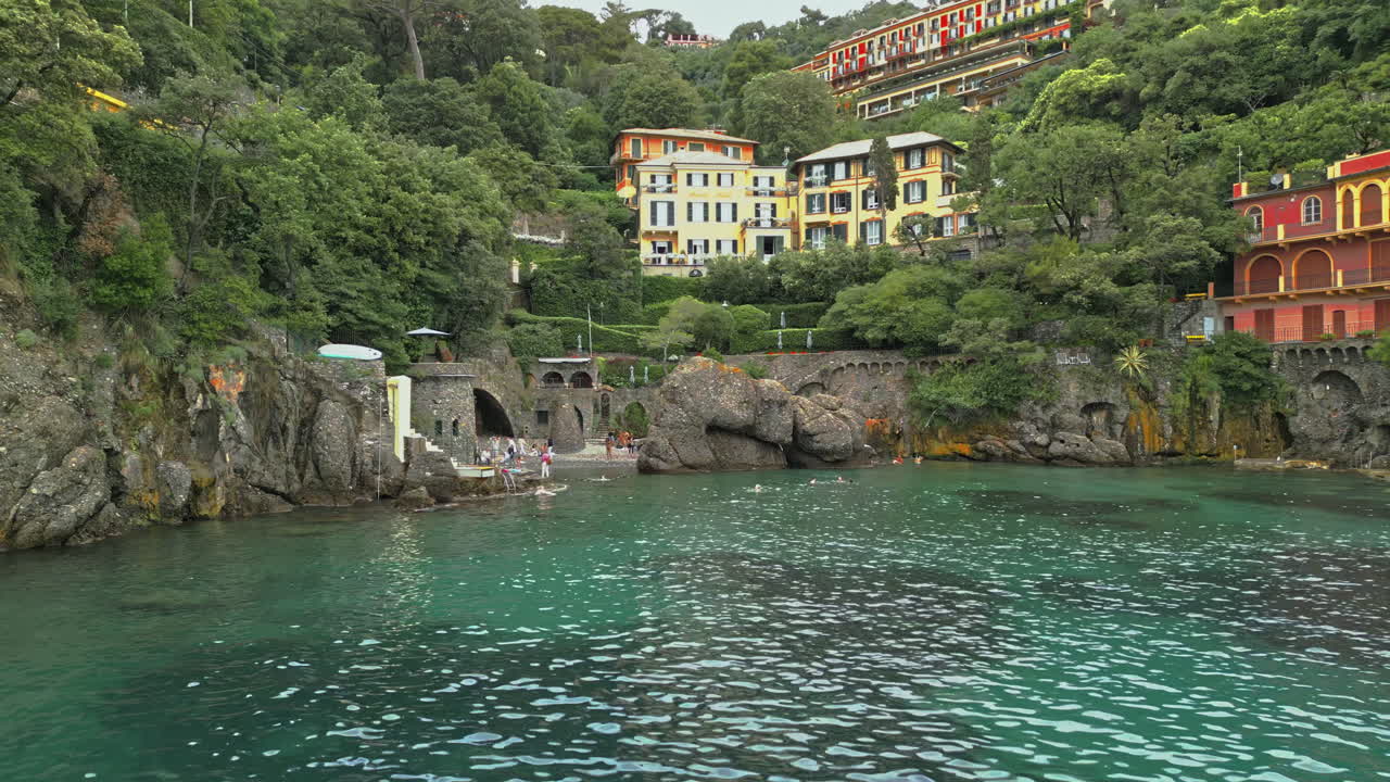 Portofino, a charming coastal town in Liguria, Italy, features vibrant villas and lush greenery along its scenic coastline