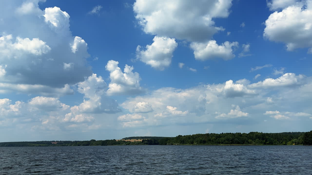 Lovely nature scenery on sunny summer day. Footage above the river under the beautiful blue cloudy sky.
