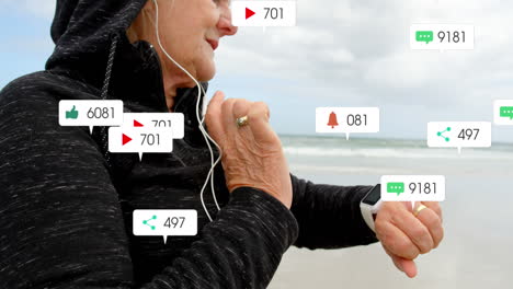 animación de barras de notificación sobre una mujer caucásica anciana con auriculares usando un reloj inteligente en la playa