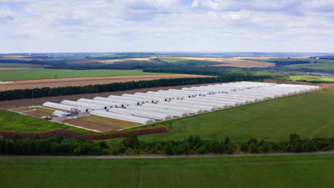 new farm on fields background. modern agricultural buildings surrounded by green nature in summer. aerial view.