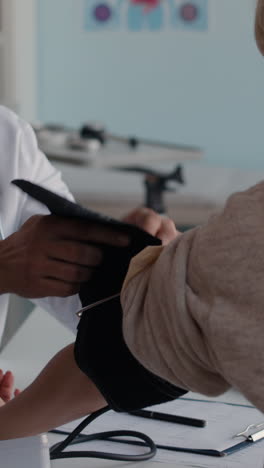 doctor checking patient's blood pressure