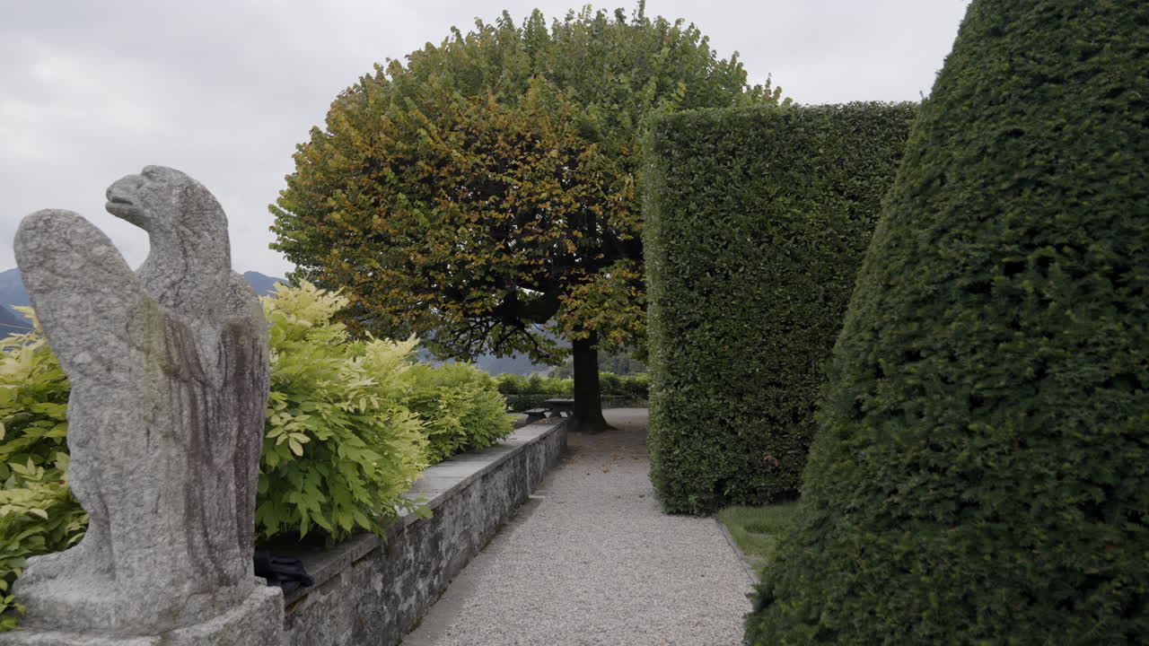 Formal garden with stone sculpture and hedges