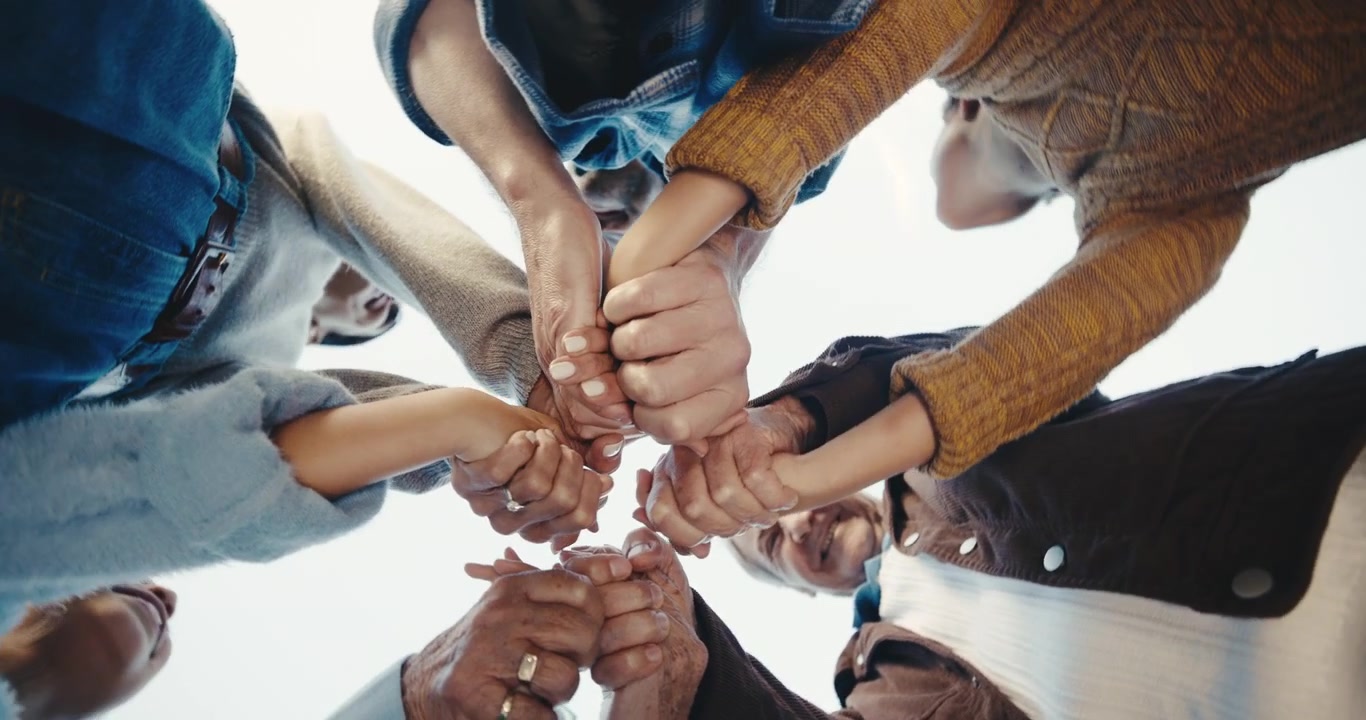 Famiglia multiculturale di diverse generazioni che si tiene per mano in cerchio