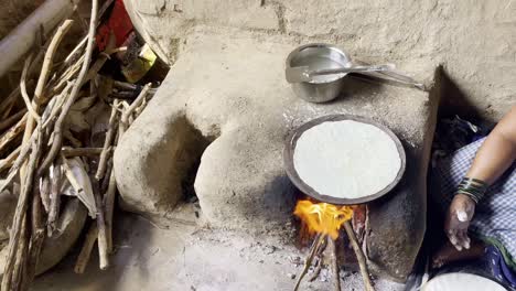 Mujer-India-Cocinando-Pan-Tradicional-Indio,-Bhakri,-Con-Leña-En-Chulhas-De-Tierra,-Maharashtra,-India,-4k