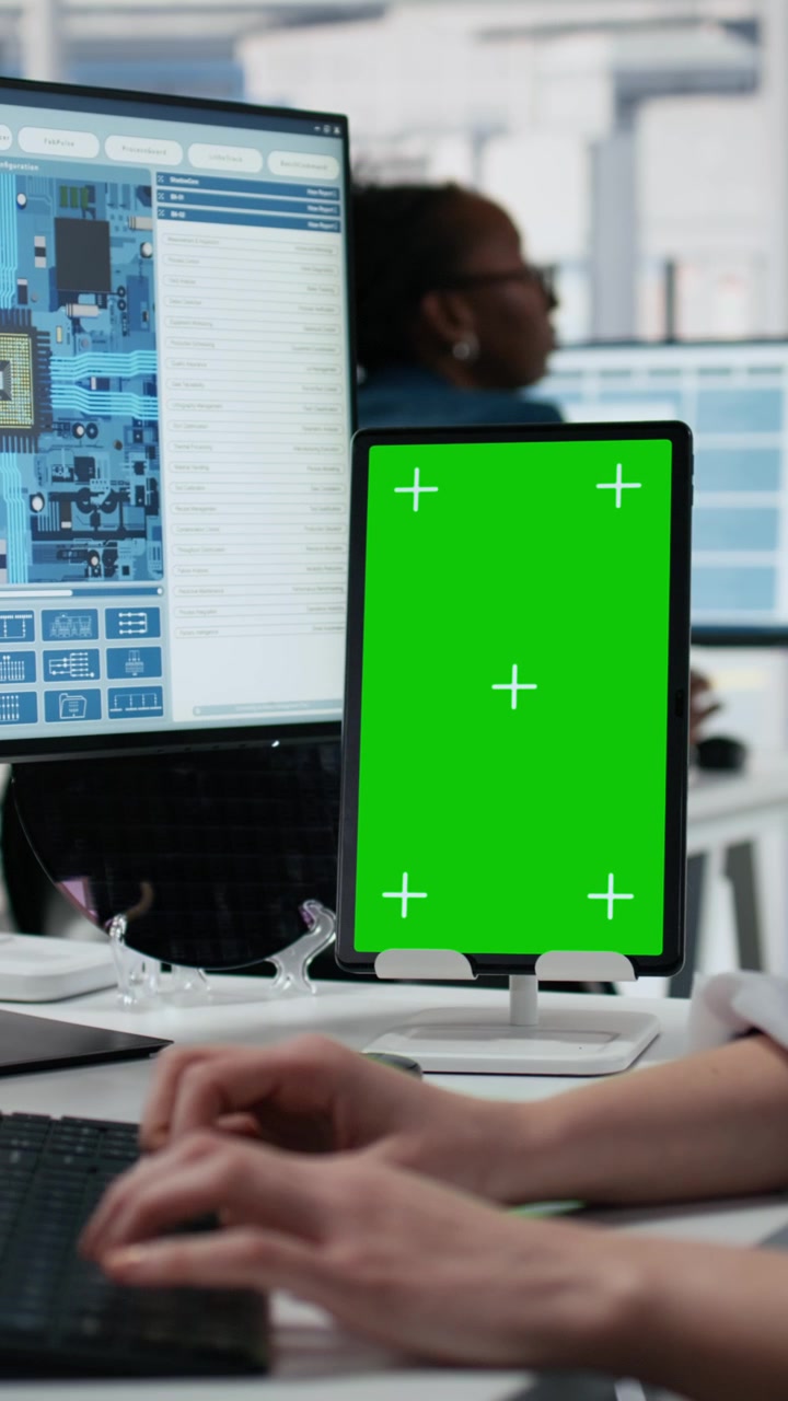 Video verticale: Tecnica che esamina circuiti di microchip usando un tablet con schermo verde (mockup).