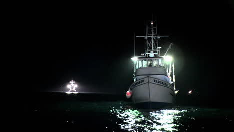 a boat sits rocking in the water at night